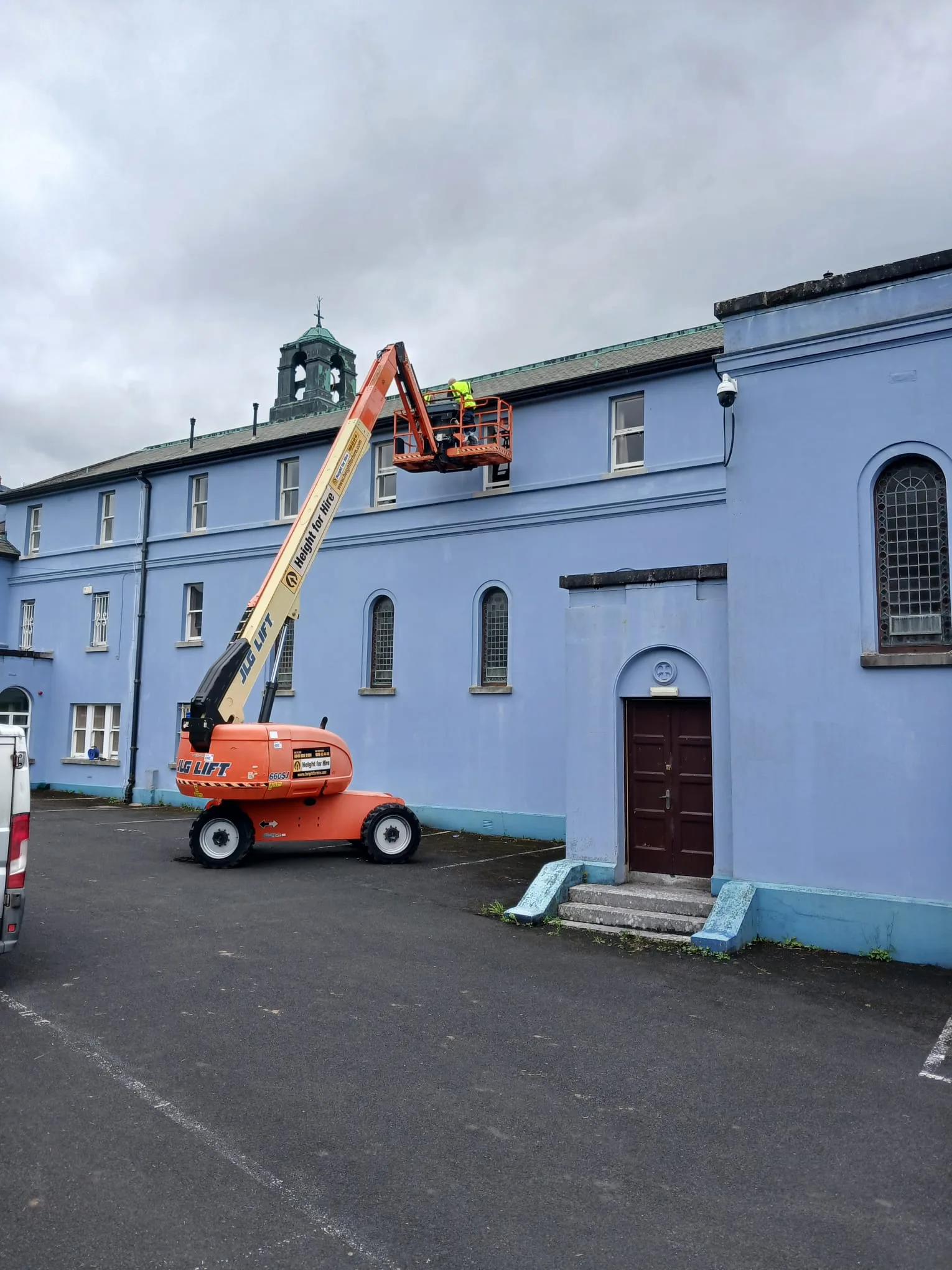 A height lift reaching the roof of a large building for roof and guttering repairs